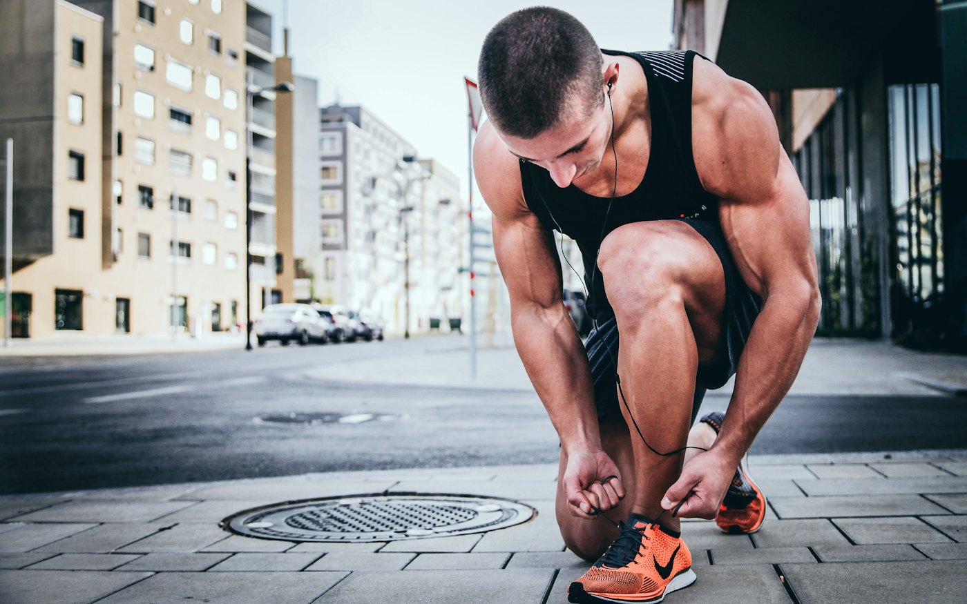 Runner tying shoelaces on a city street